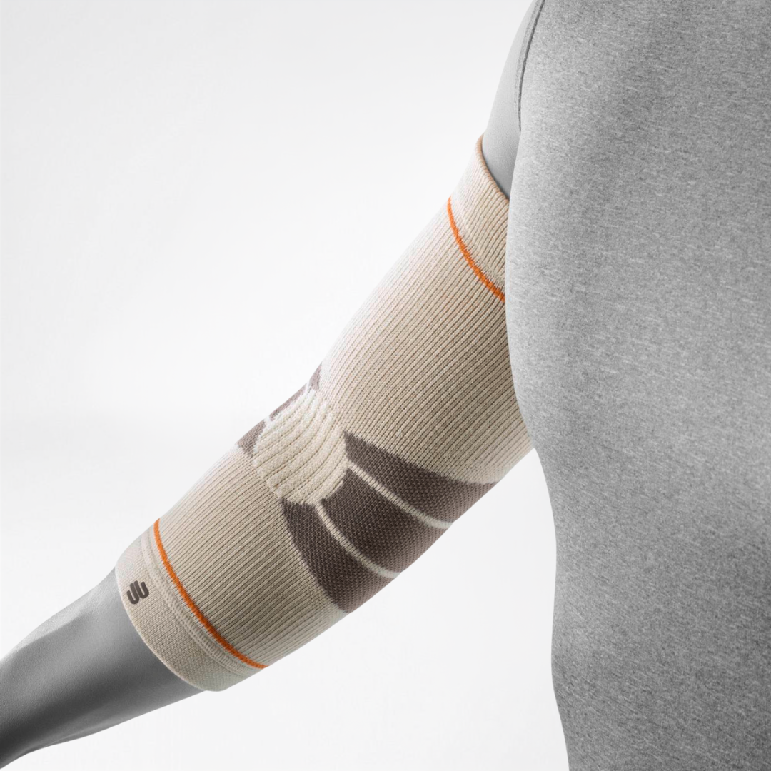 A close-up of a person's arm wearing a Bauerfeind Sports outdoor elbow compression sleeve with a light gray background.