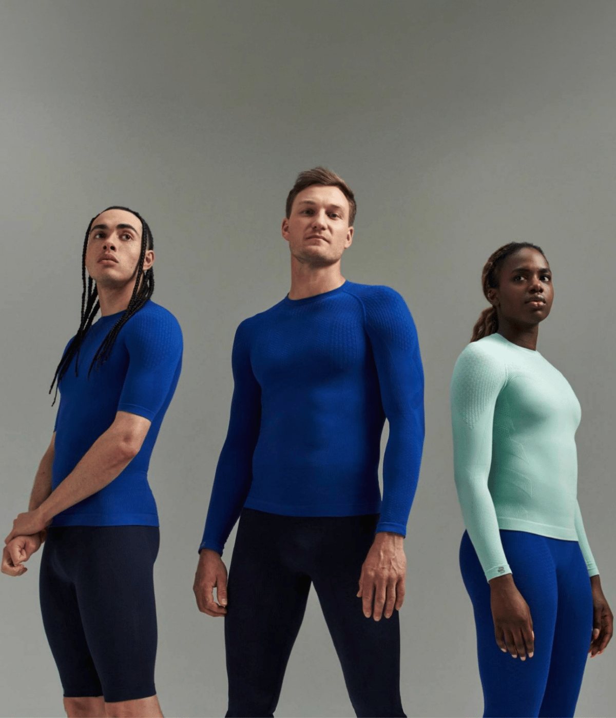Three people wearing Bauerfeind sport compression wear collection against a gray background