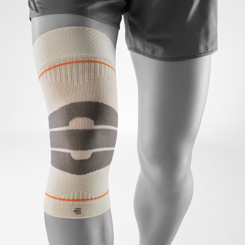 Knee brace on a person's leg with a gray background