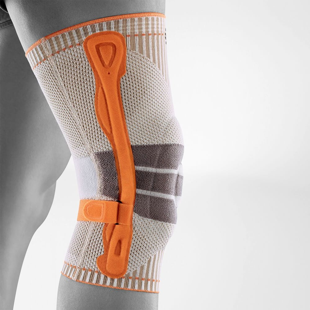 Knee brace with orange straps on a gray background
