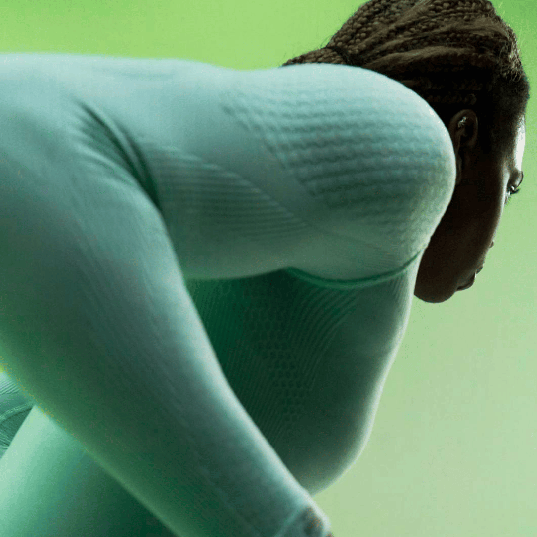 Person wearing a mint bauerfeind sport compression shirt against a green background