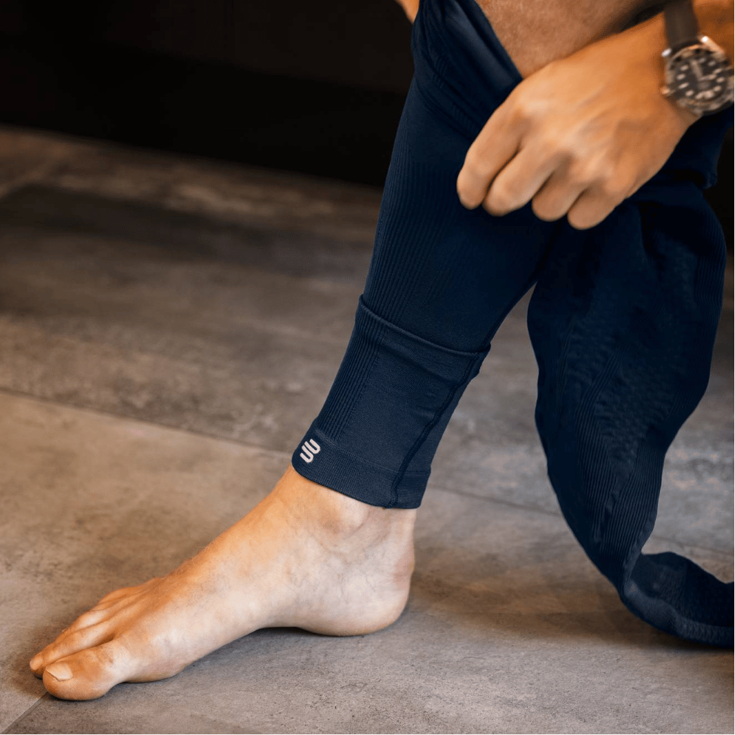 Person putting on navy blue bauerfeind sports compression leggings
