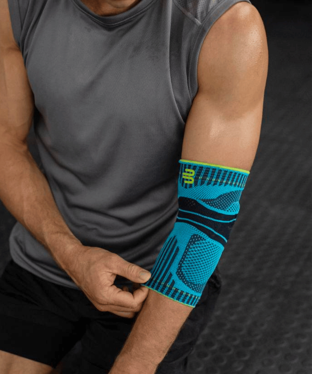 Person wearing a blue and black compression sleeve on their arm against a dark background