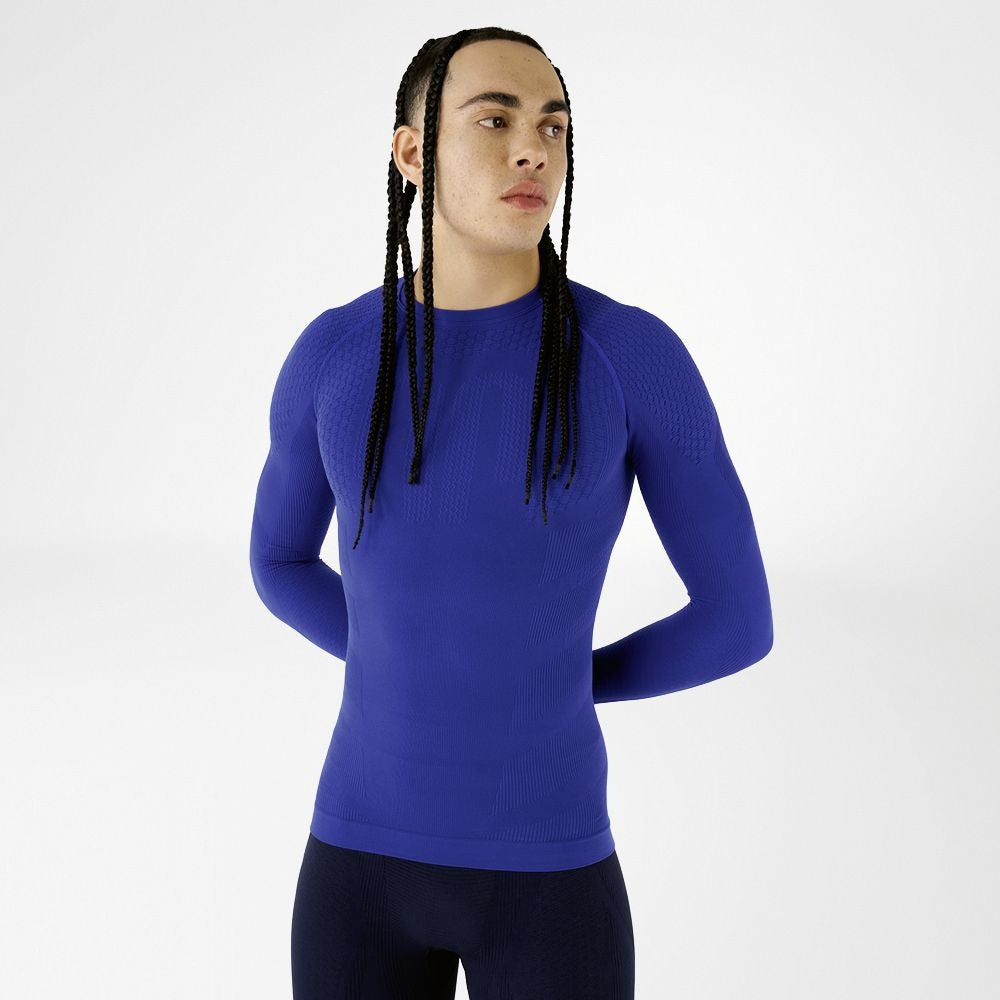 Person wearing blue athletic Bauerfeind men's Sports Compression long Sleeve Shirt and Navy blue Bauerfeind's Men Sport compression shorts on a white background