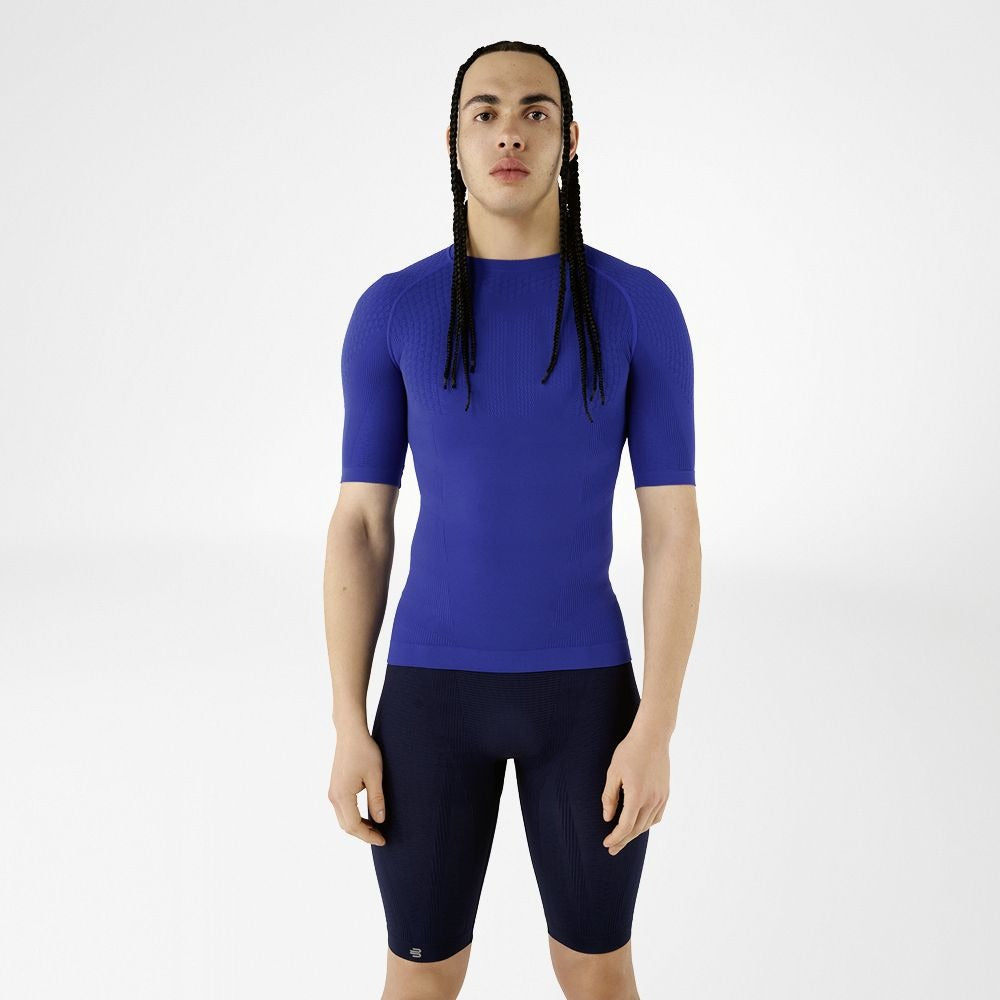 Person wearing blue athletic Bauerfeind men's Sports Compression Short Sleeve Shirt and Navy blue Bauerfeind's Men Sport compression shorts on a white background