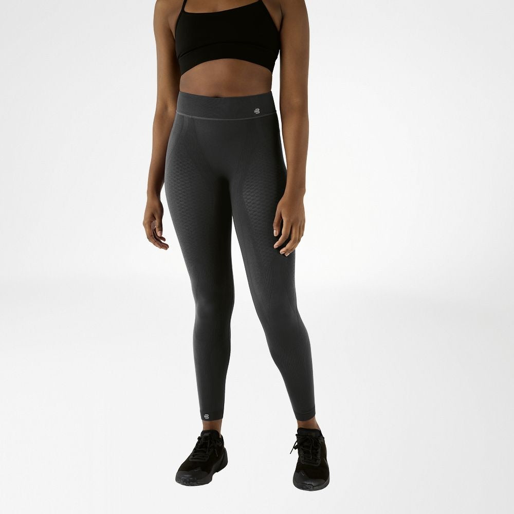 Person wearing grey athletic Bauerfeind Women's sport compression Leggings and black sports bra on a white background