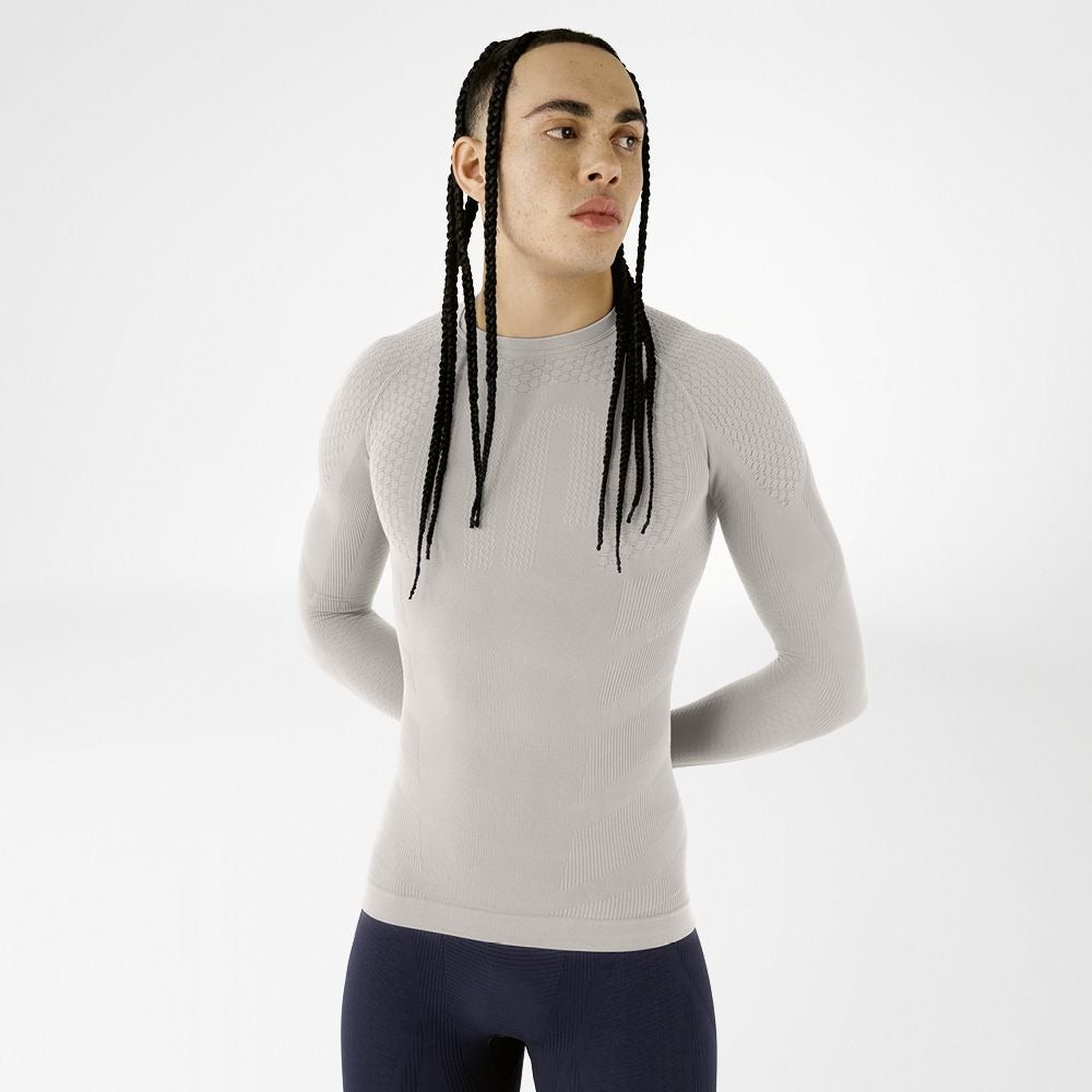 Person wearing silver athletic Bauerfeind men's Sports Compression long Sleeve Shirt and Navy blue Bauerfeind's Men Sport compression shorts on a white background