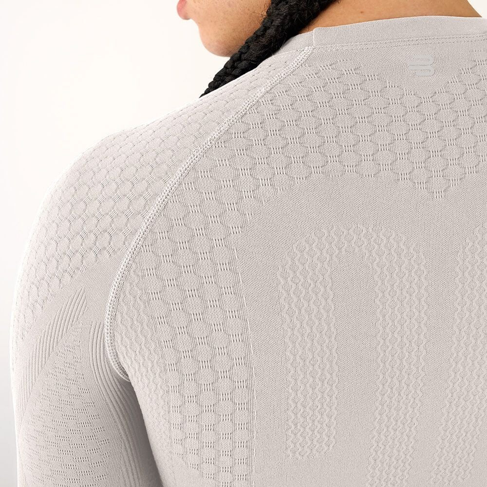 Close-up of the texture on silver Bauerfeind men's sport compression long-sleeve shirt on a white background