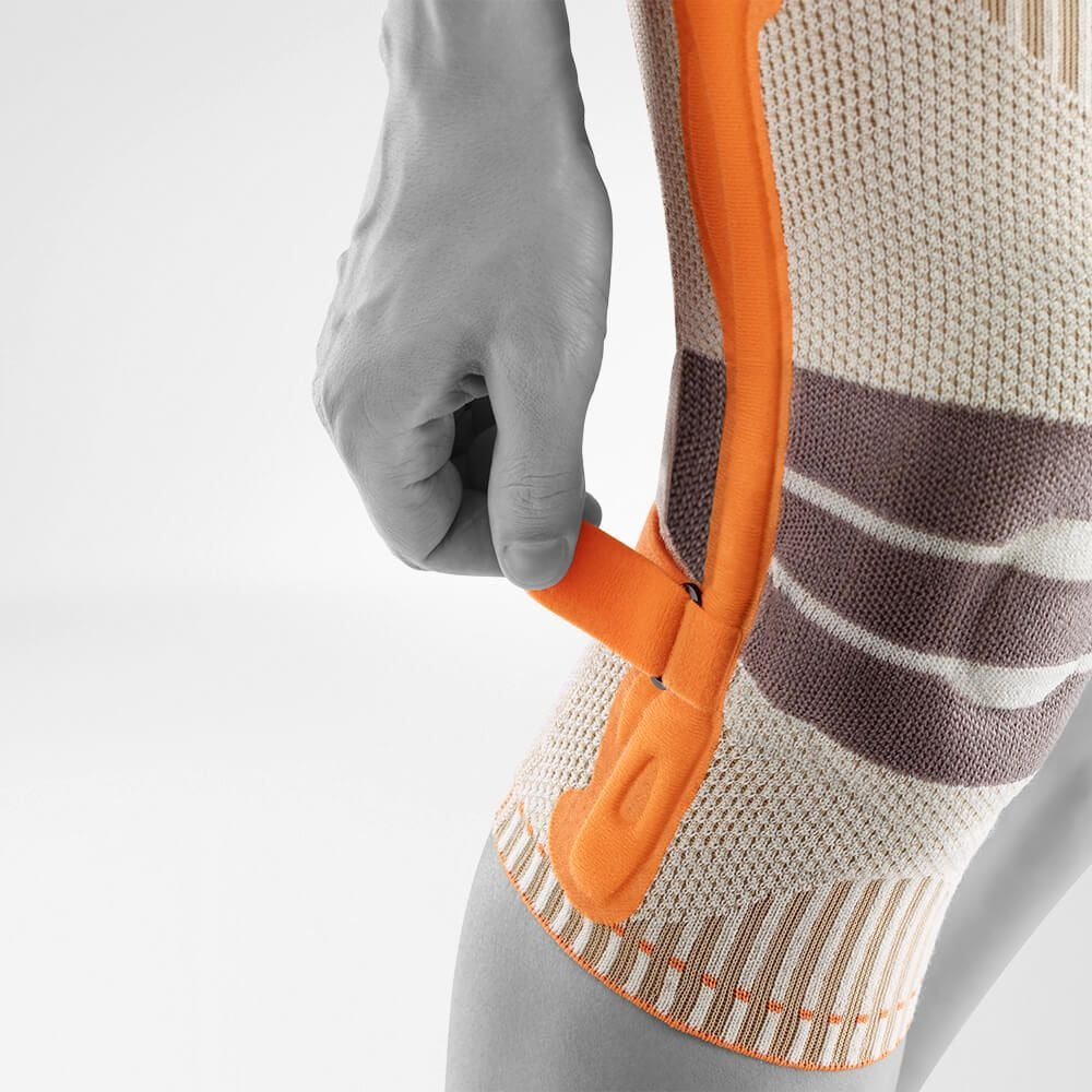 Person adjusting the tension strap on a knee brace