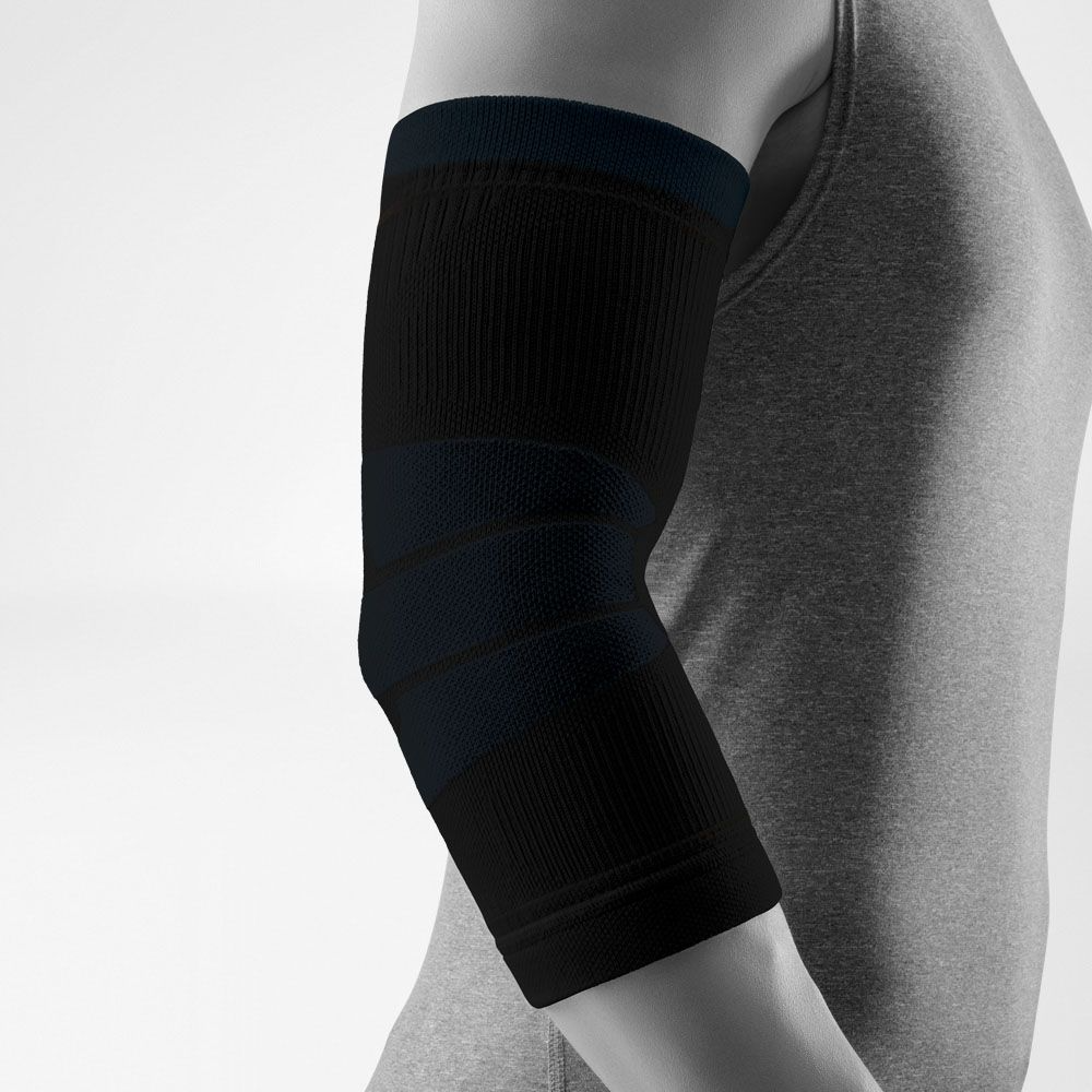 A close-up of a person's arm wearing a Black Bauerfeind Sports outdoor elbow compression sleeve with a light gray background.