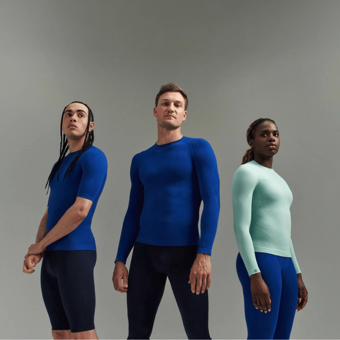 Three people wearing Bauerfeind sport compression wear collection against a gray background