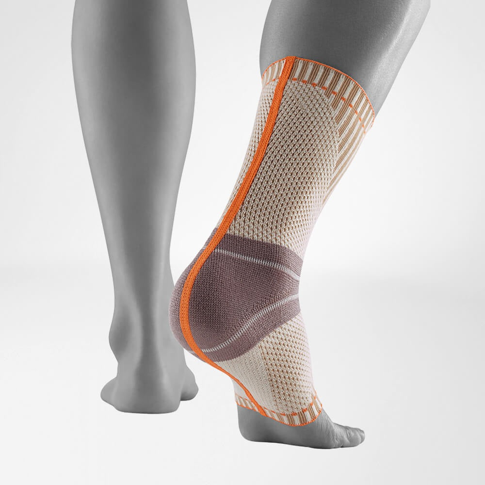 Compression support with orange accents on a gray mannequin leg against a white background