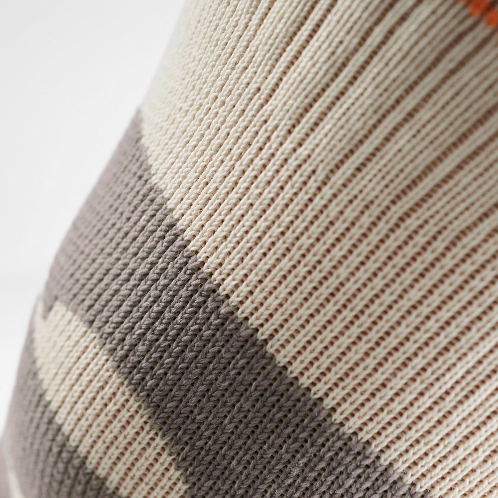 Close-up of a patterned knee sleeve with brown and beige colors on a light gray background