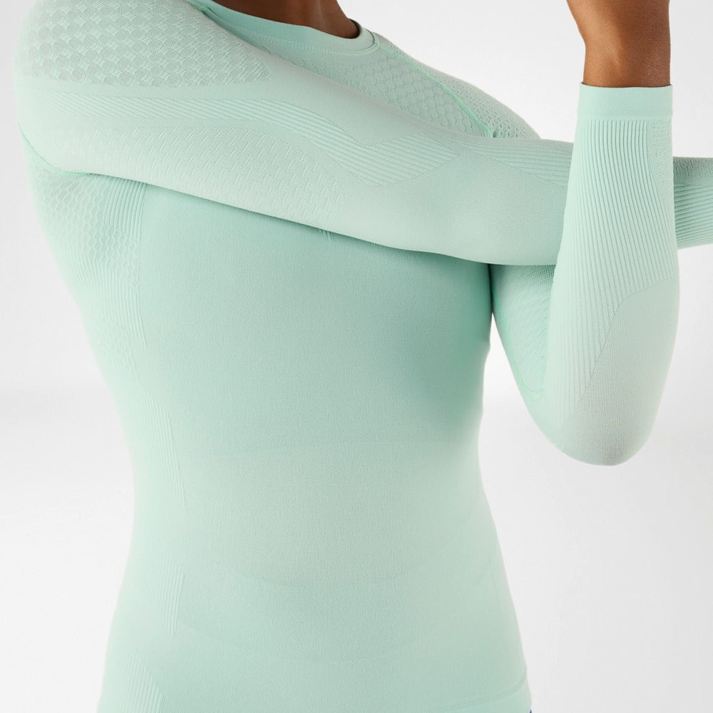Light green ribbed bauerfeind compression long sleeve worn by a person on a white background