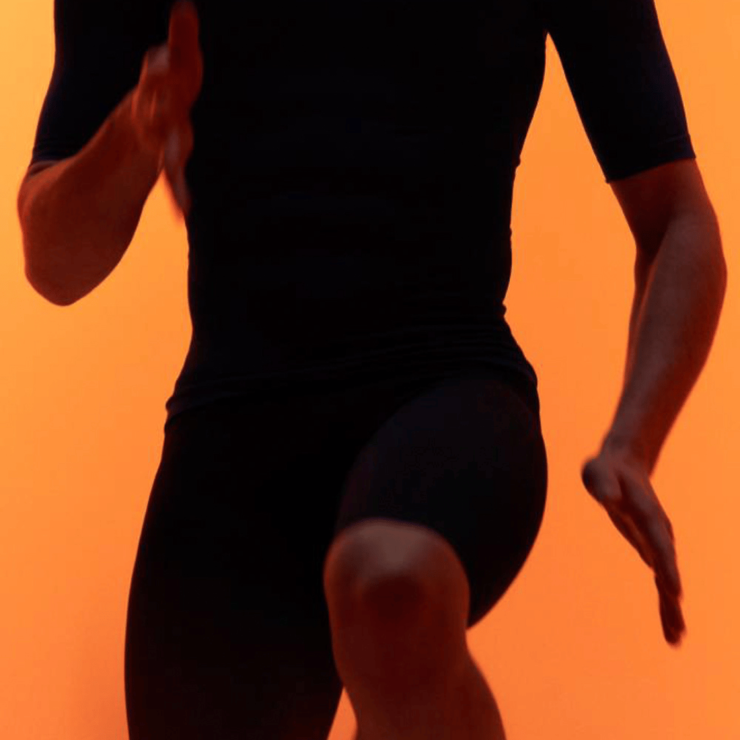 Person running with a blurred background, wearing bauerfeind compression wear shorts and shirt