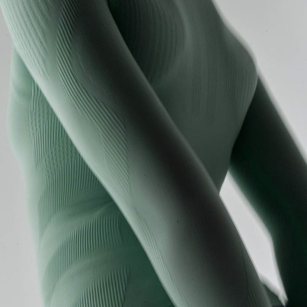 Close-up of a mint Bauerfeind women's sport compression long-sleeve shirt on a neutral background