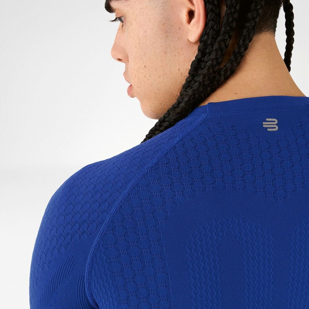 Blue Bauerfeind's Men Sport compression shirt worn by a person on a white background with a closeup of a logo