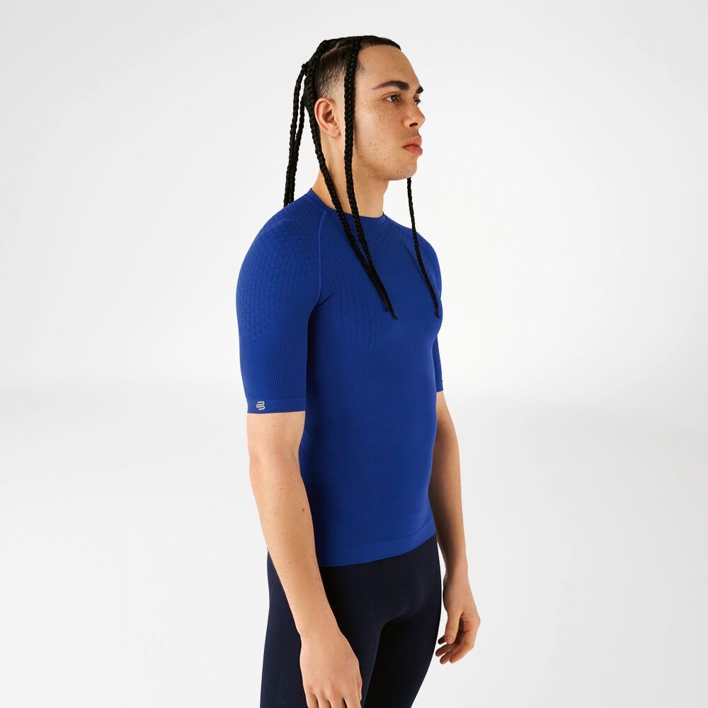 Person wearing blue athletic Bauerfeind men's Sports Compression Short Sleeve Shirt and Navy blue Bauerfeind's Men Sport compression shorts on a white background