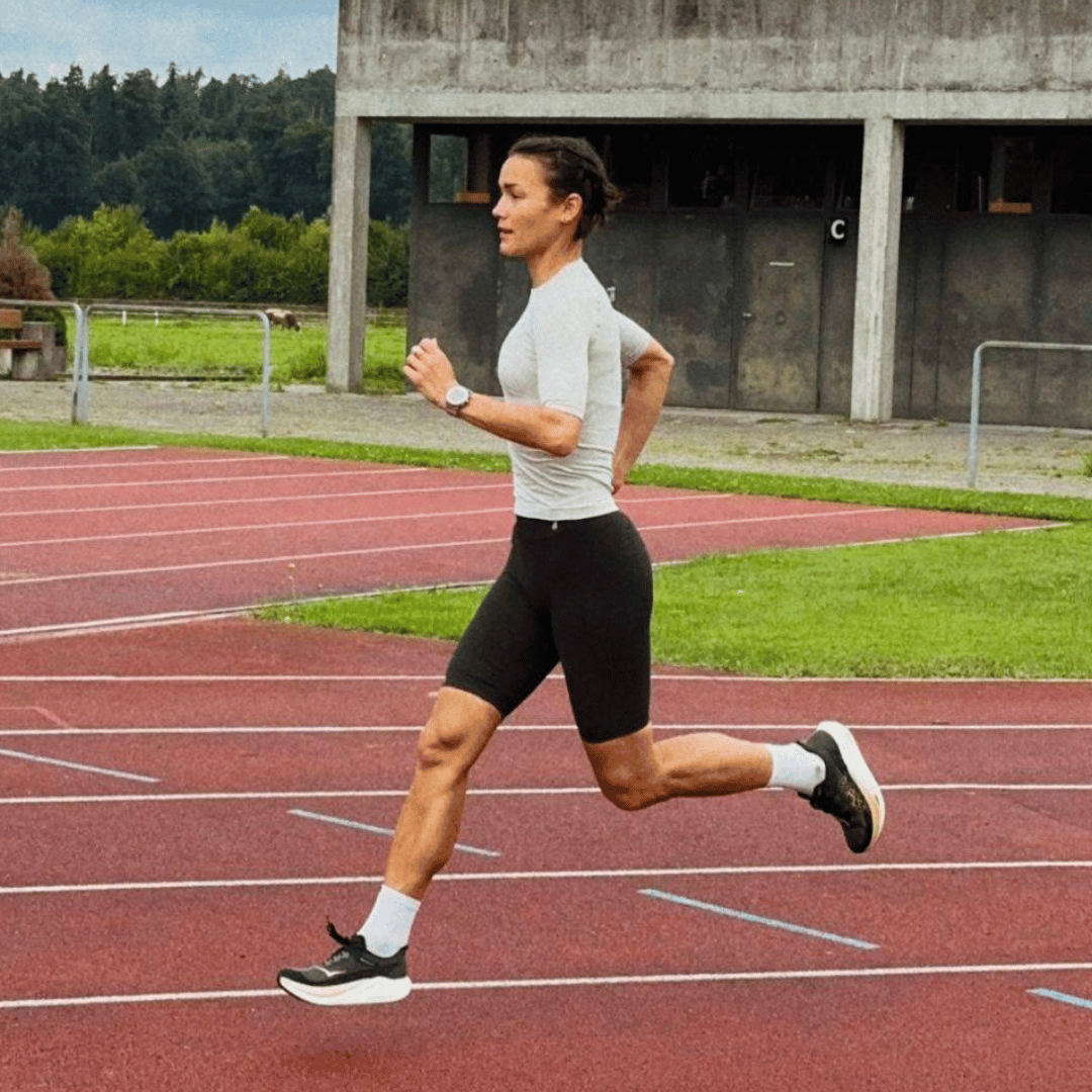 Person running on a track in athletic Bauerfeind Women's sport compression shorts