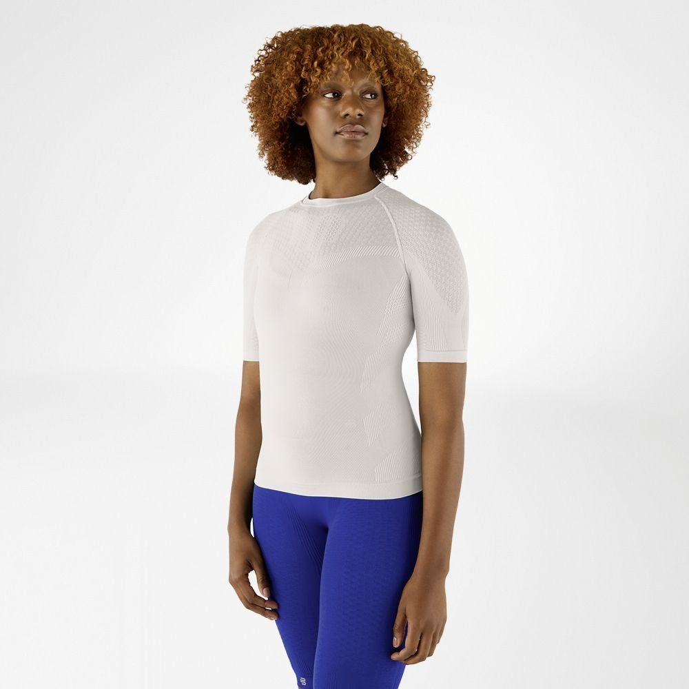 Person wearing light grey silver athletic Bauerfeind Women's Sports Compression Short Sleeve Shirt and blue Bauerfeind Women's sport compression shorts on a white background