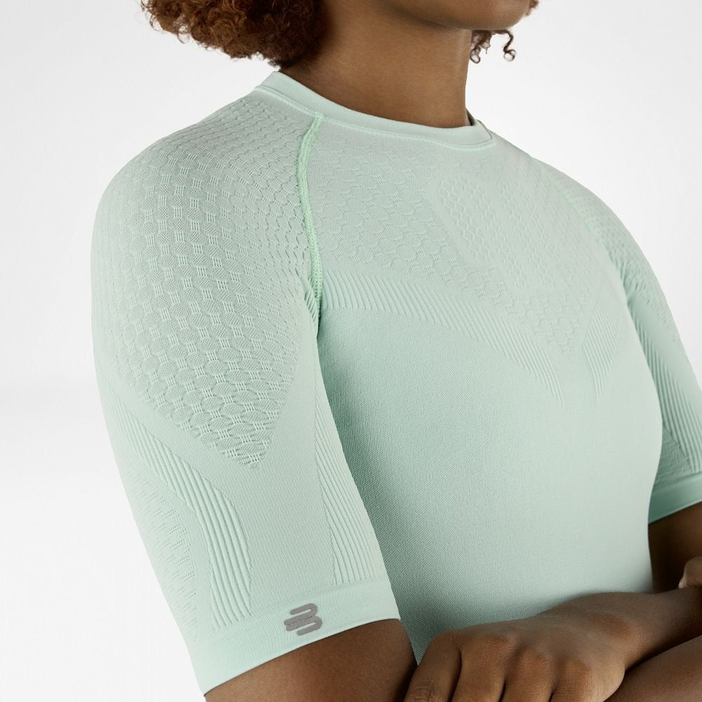 Person wearing minty green athletic Bauerfeind Women's Sports Compression Short Sleeve Shirt on a white background