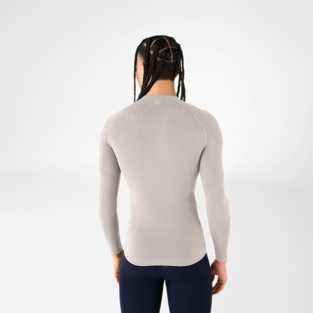 Person wearing silver athletic Bauerfeind men's Sports Compression long Sleeve Shirt and Navy blue Bauerfeind's Men Sport compression shorts on a white background