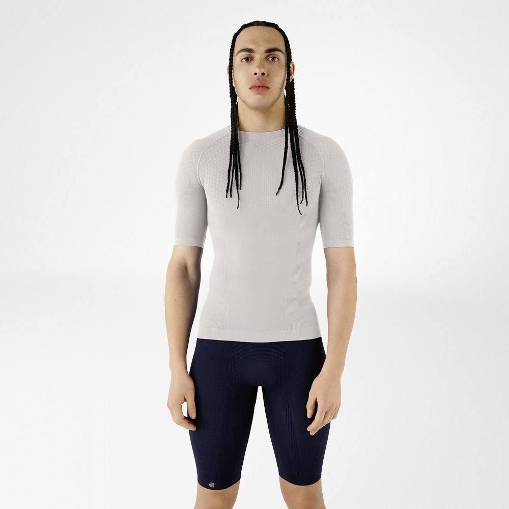 Person wearing silver athletic Bauerfeind men's Sports Compression Short Sleeve Shirt and Navy blue Bauerfeind's Men Sport compression shorts on a white background