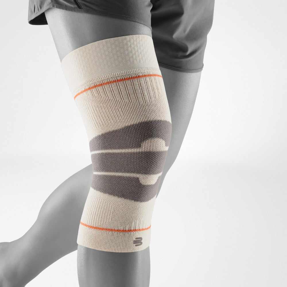 Knee compression sleeve with orange accents on a gray mannequin leg against a white background